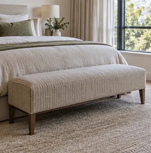 Long upholstered bench at the foot of a bed