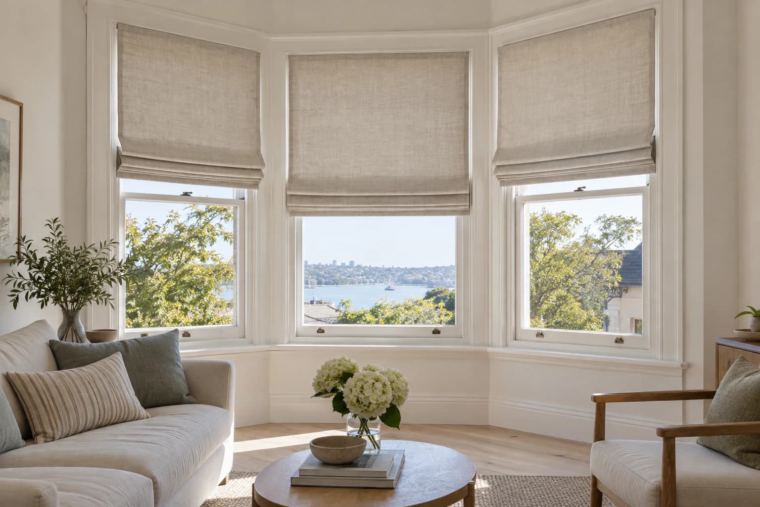 Three coordinated Roman blinds designed as one composition across an angled bay window.