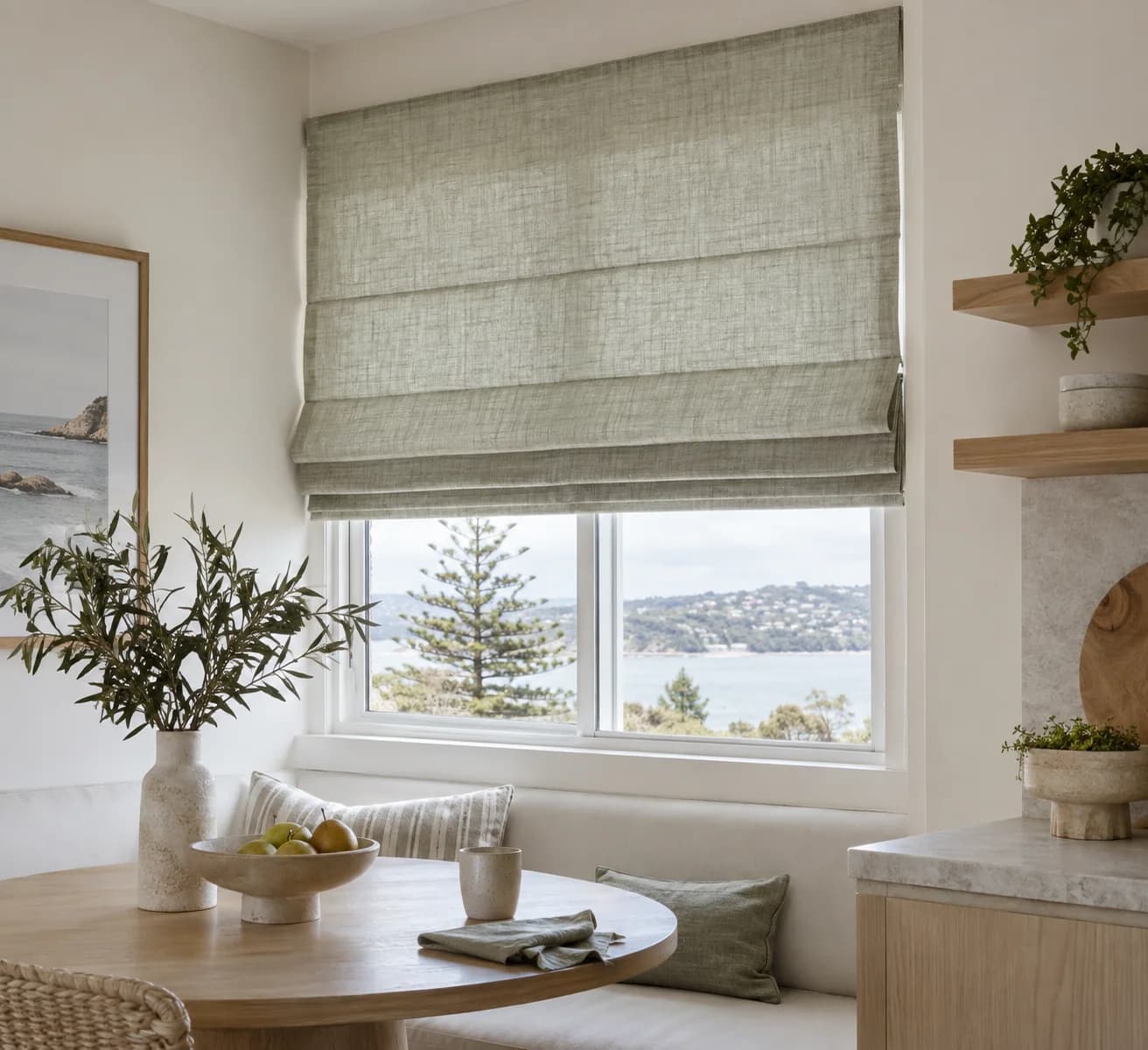 Pale sage linen Roman blind in a coastal breakfast nook