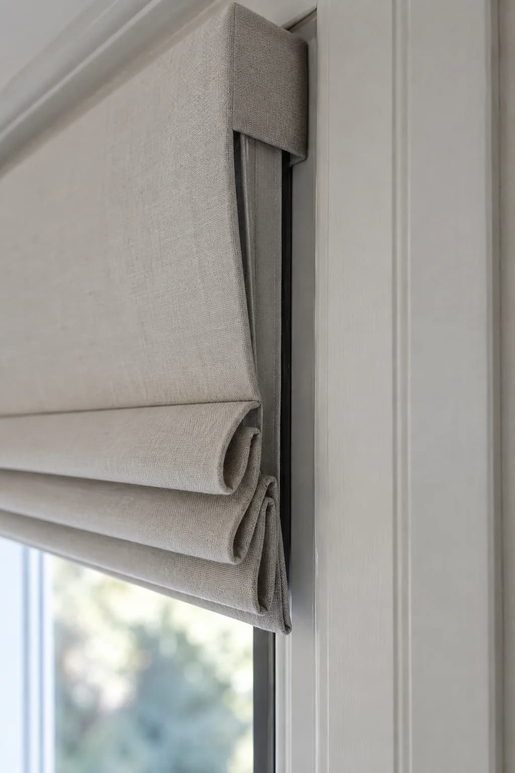 Close side view of a neatly fitted motorised Roman blind
