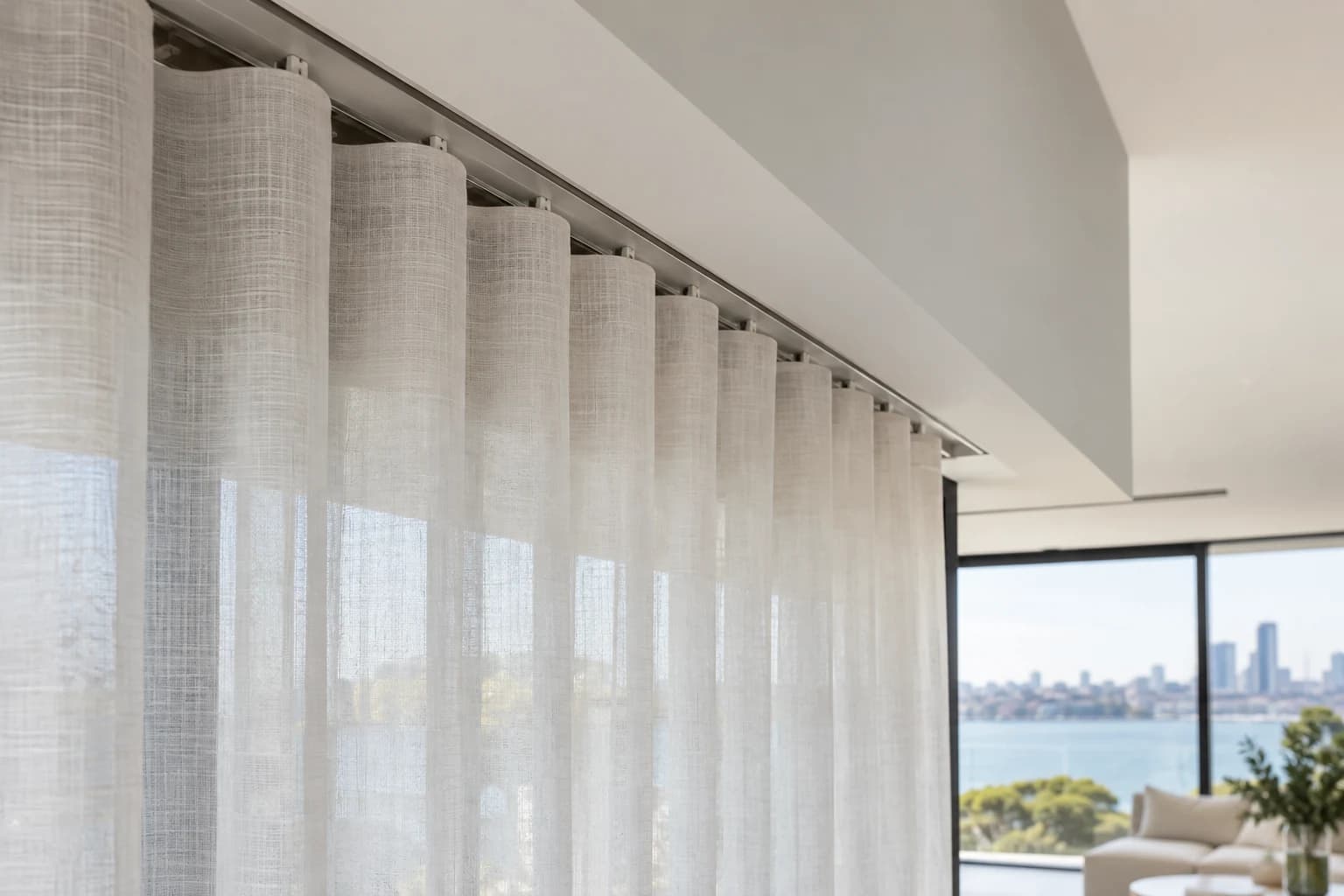 Installed motorised curtain track meeting a full-height curtain heading
