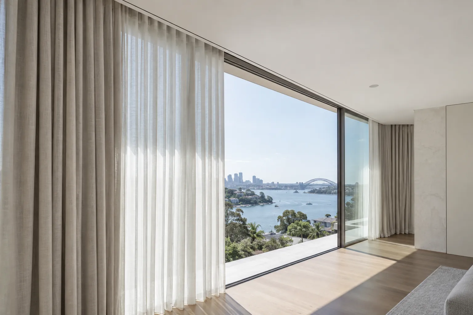 Full-height curtains integrated with a recessed ceiling track at broad glazing