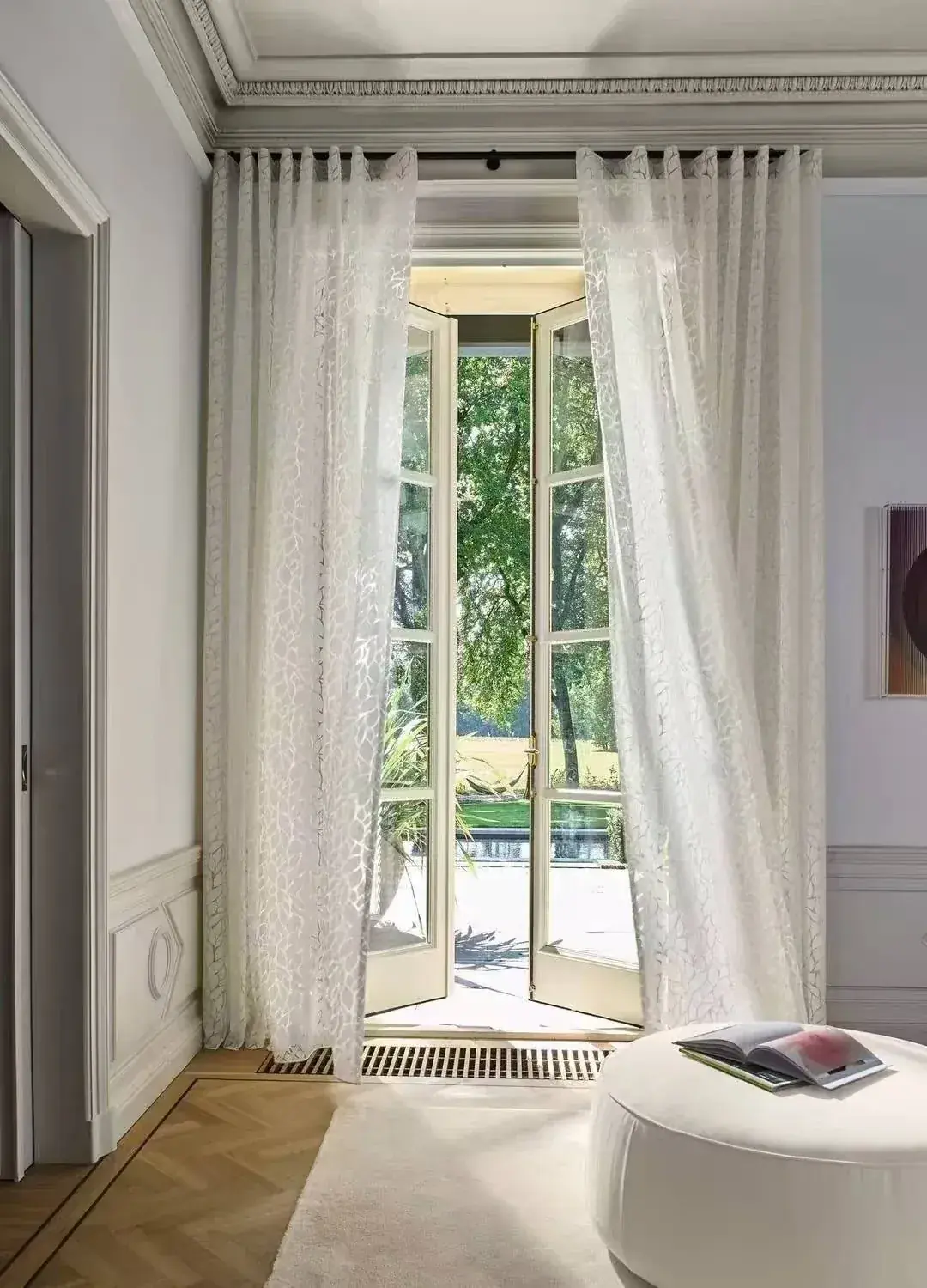 Full-height sheer curtains filtering daylight in a calm interior