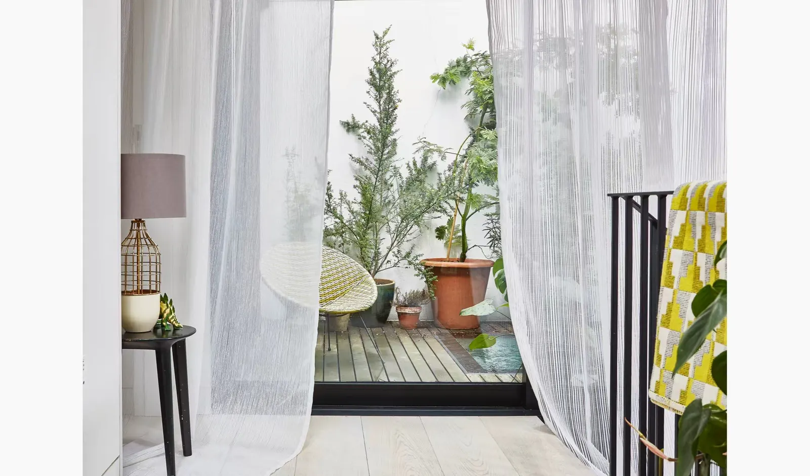 Full-height neutral sheers filtering daylight in a bright living space