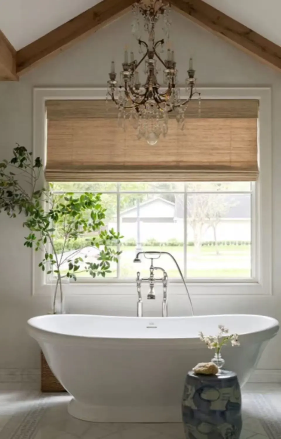 Natural linen Roman blind fitted above a freestanding bath in a light-filled room
