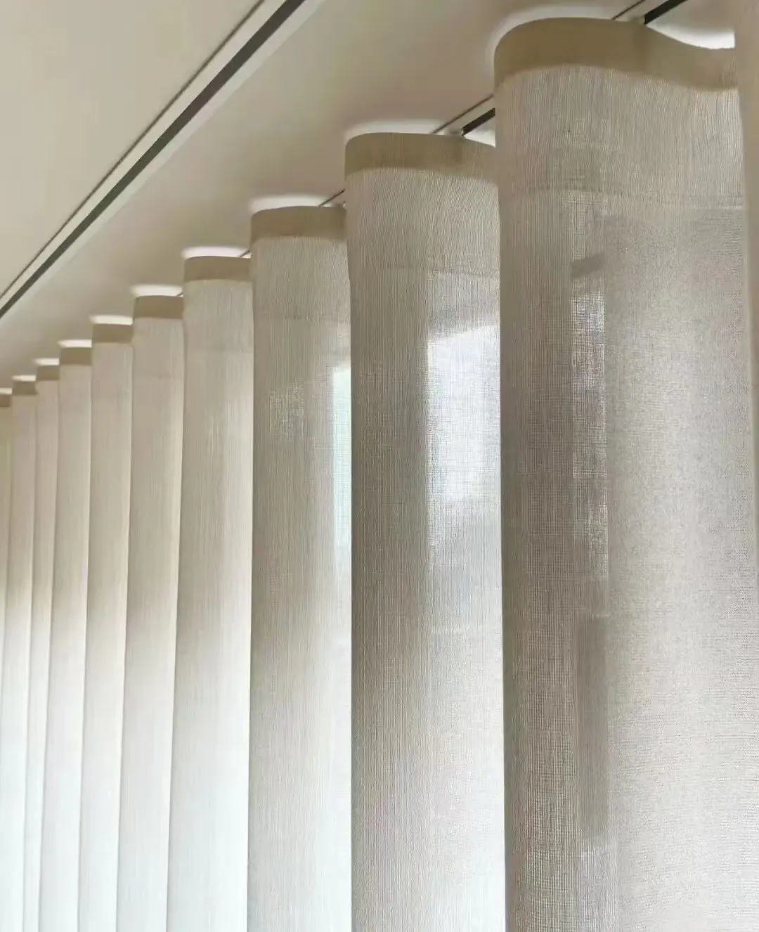 Close architectural view of light passing through evenly formed sheer curtain folds