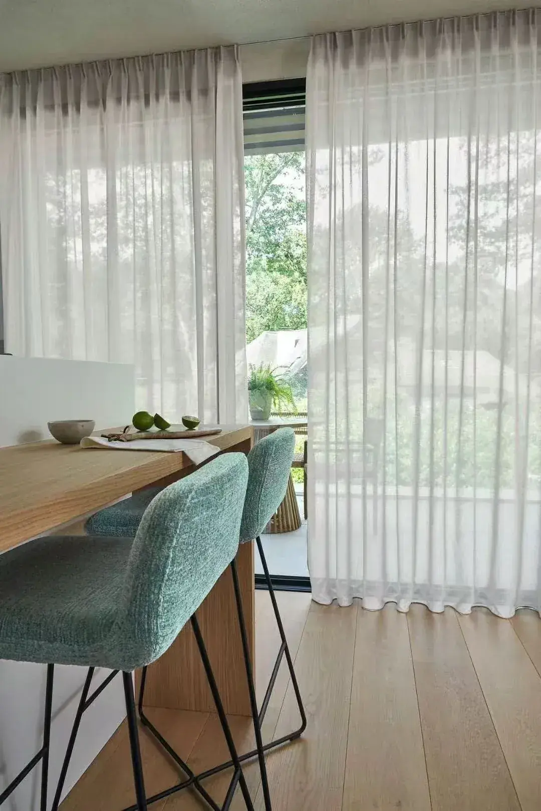 Sheer curtains integrated with a dining table and surrounding interior