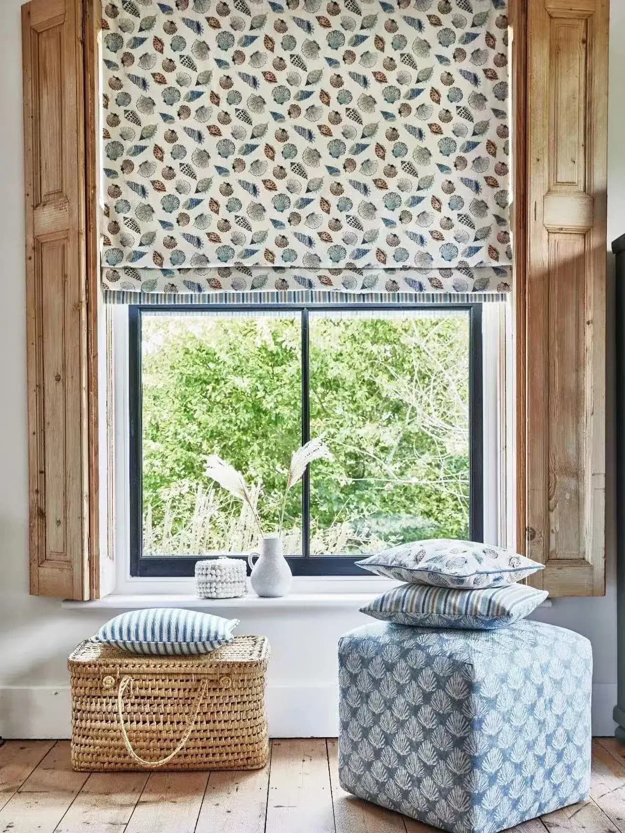 Archive view of a patterned fabric Roman blind centred within a timber window reveal