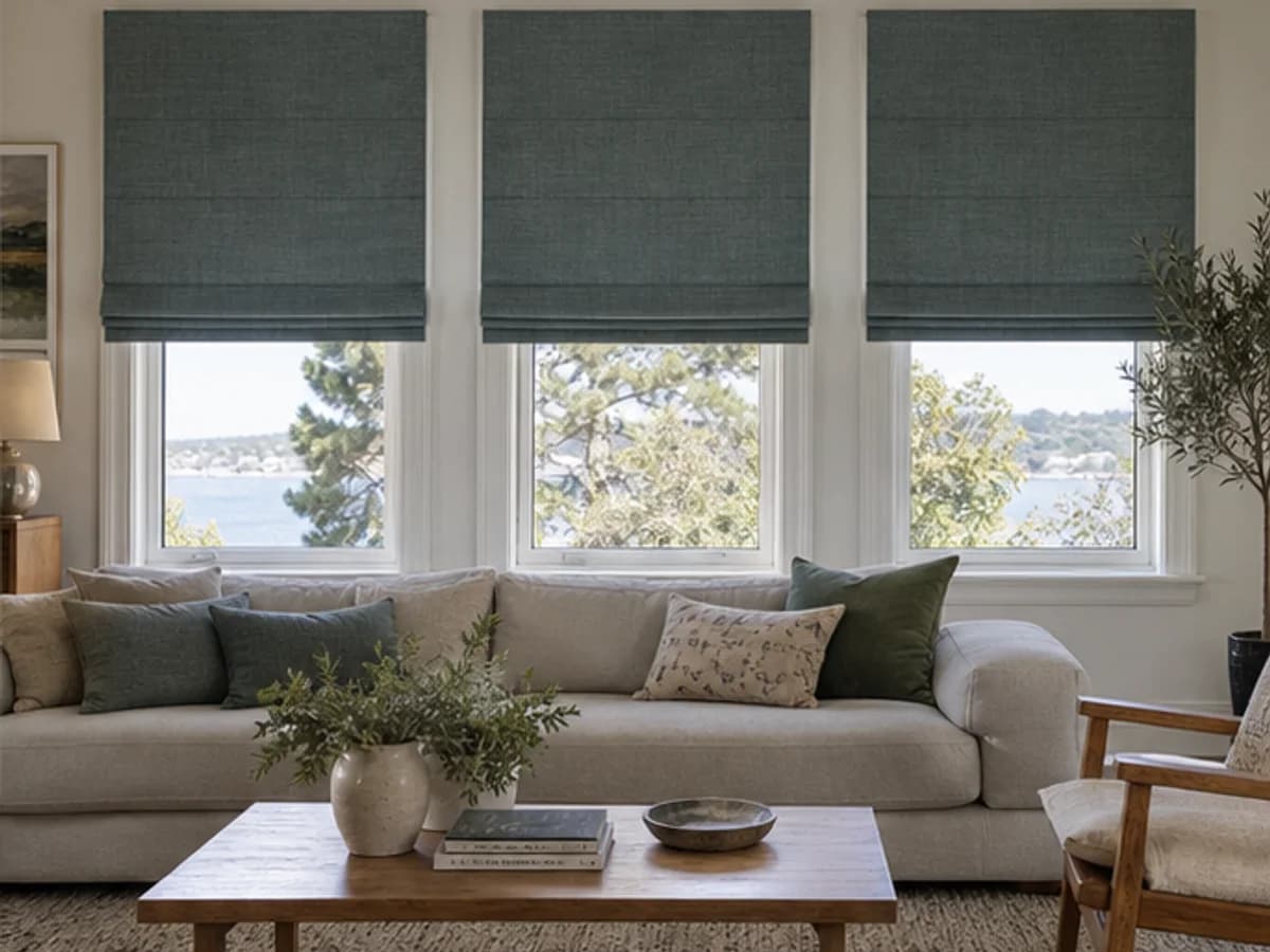 Three aligned blue-green Roman blinds fitted to a wide living-room window elevation