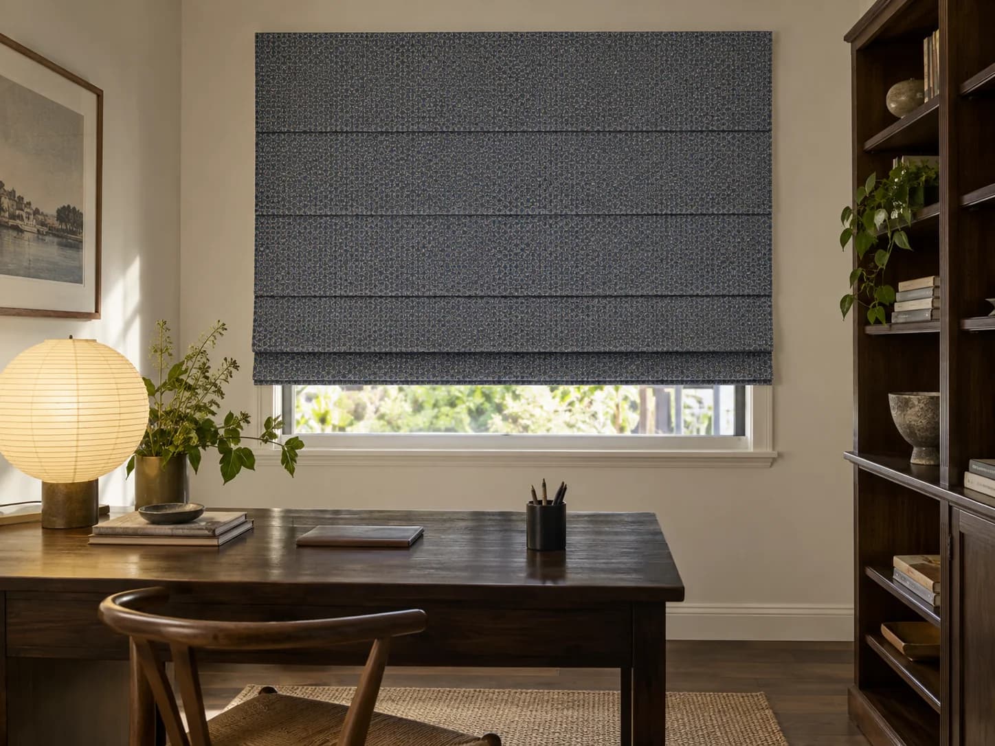 Structured Classic Roman blind in a centred dusty-blue geometric textile above a home study desk