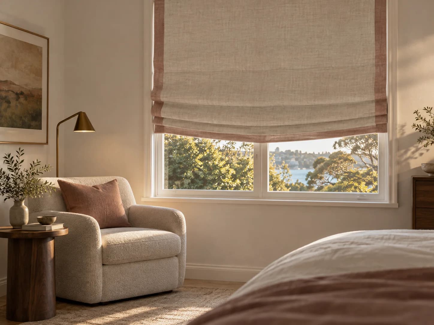 Soft flax Roman blind with a deliberate relaxed centre line and muted rose border in a bedroom