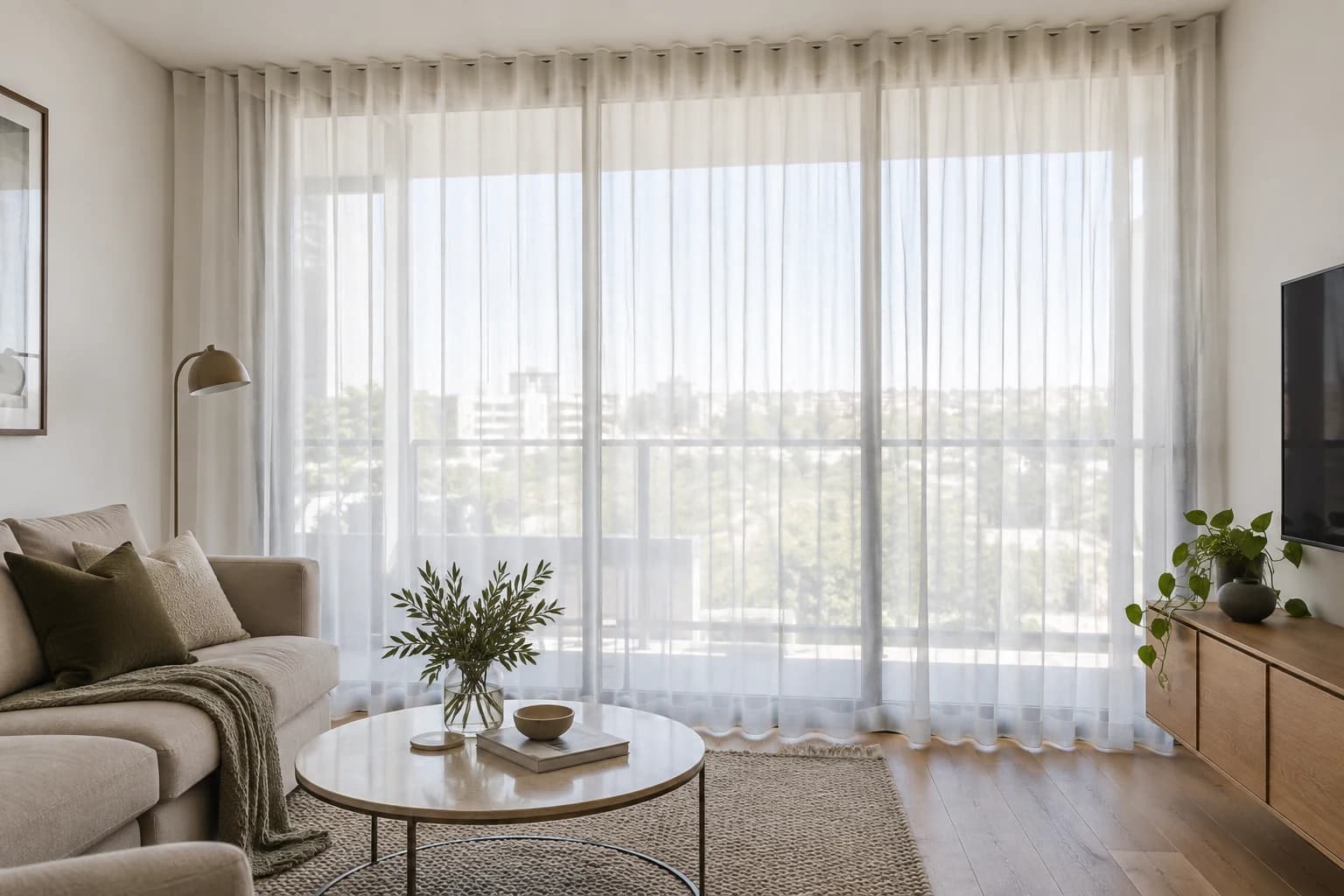 Daylight passing through a full-height sheer across apartment glazing
