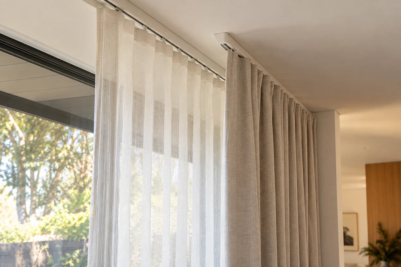 Close view of a layered curtain track and heading arrangement
